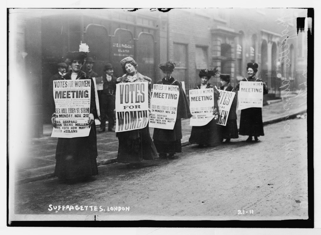 Suffragette with posters demanding votes for women, London, undated. Source: Library of Congress.